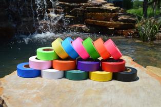 Colorful tapes stacked on a rock outdoors.