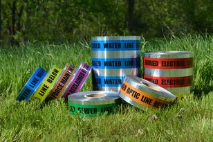 Colorful utility marking tapes on grass.