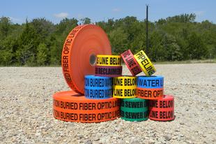 Colorful utility marking tapes on gravel.